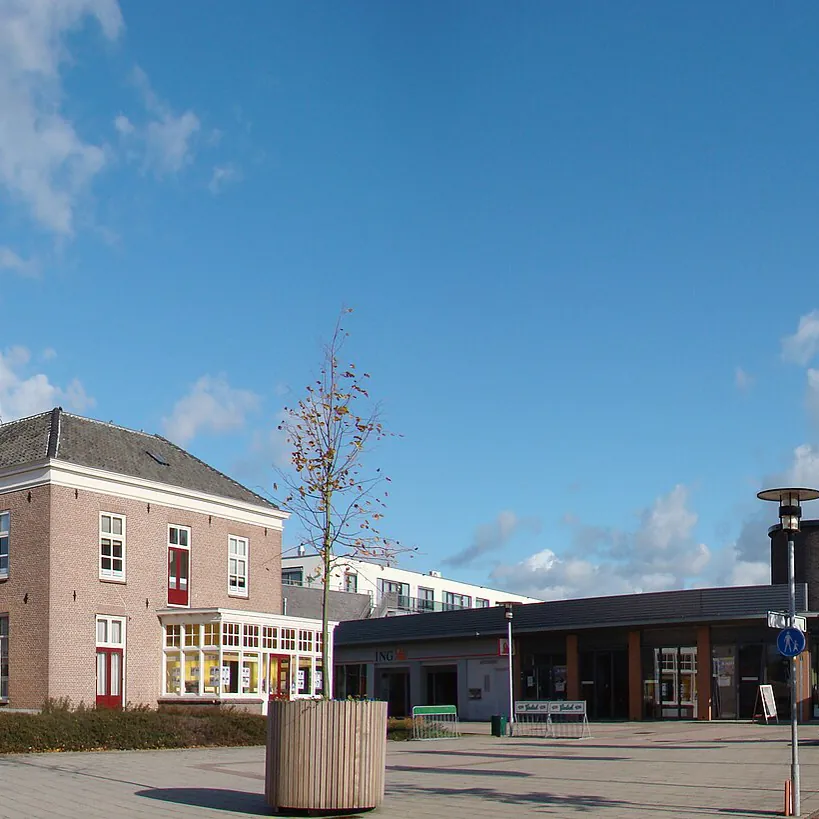Een plein met winkels en gebouwen in Duiven: alle rijscholen in Duiven op een rij