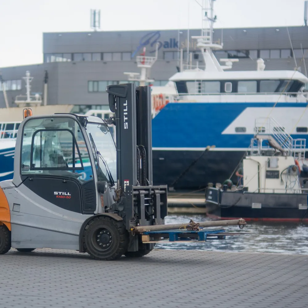 Een heftruck op de kade in de haven van Urk: alle rijscholen in Urk op een rij